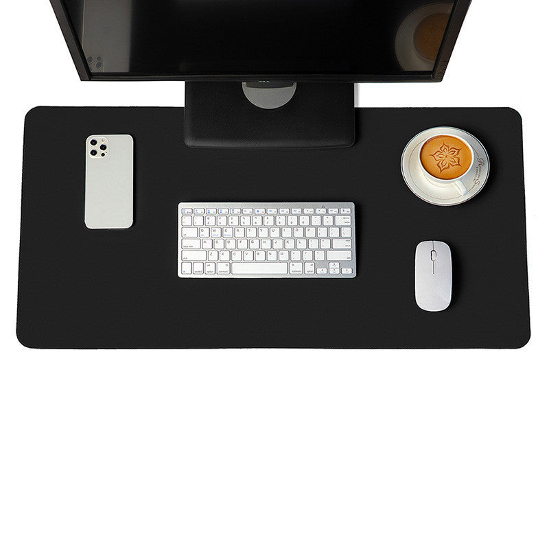 Black desk mat and mouse pad featured in a sleek and modern desk setup with white keyboard and mouse.