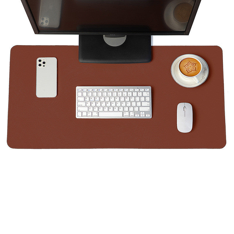 Brown desk mat and mouse pad with a leather finish, used in a classic office setting with a monitor and accessories.