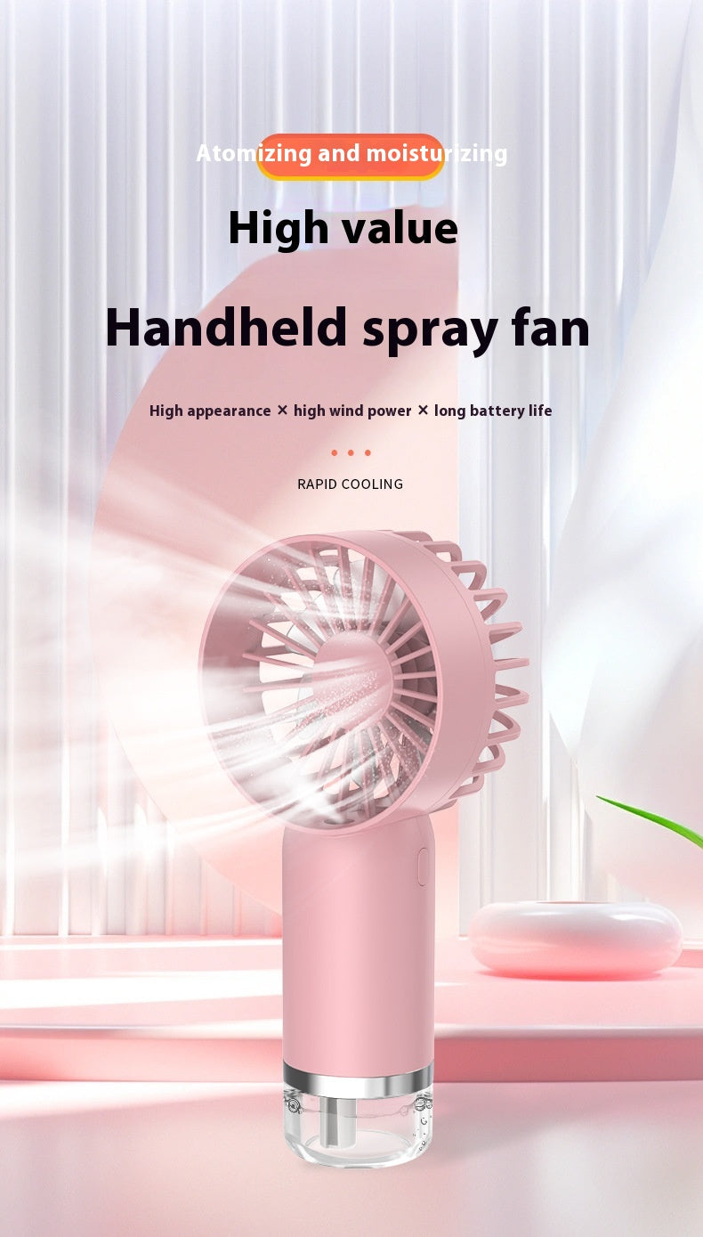 Pink handheld mist spray fan in use, blowing cooling air with soft lighting in modern indoor setting