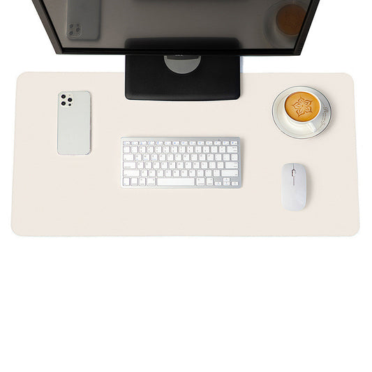 Beige desk mat and mouse pad on a workspace with a monitor, keyboard, and coffee, ideal for a clean and professional desk setup.